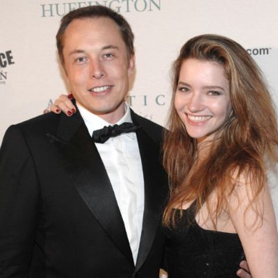 She is wearing a black dress while he is wearing a tuxedo.